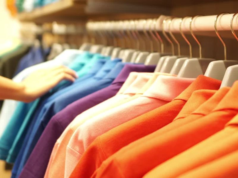 osoba gleda sakoe i košulje u prodavnici