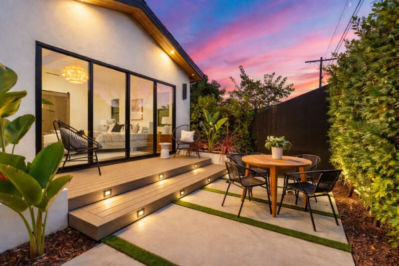 Moderna terasa sa stolom stolicama i osvetljenjem u uređenom dvorištu